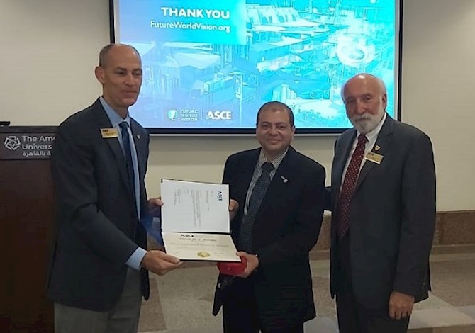 Dr. Moussa with President Truax and Executive Director Smith in Cairo, Egypt. Pictured are three people looking at the camera smiling. Two of them are holding the award. 