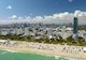 Aerial of Florida coastal cityscape with ocean and beach in foreground, hotels and condominiums behind