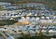 Aerial view of housing development with finished and unfinished homes and highway on lower left of image