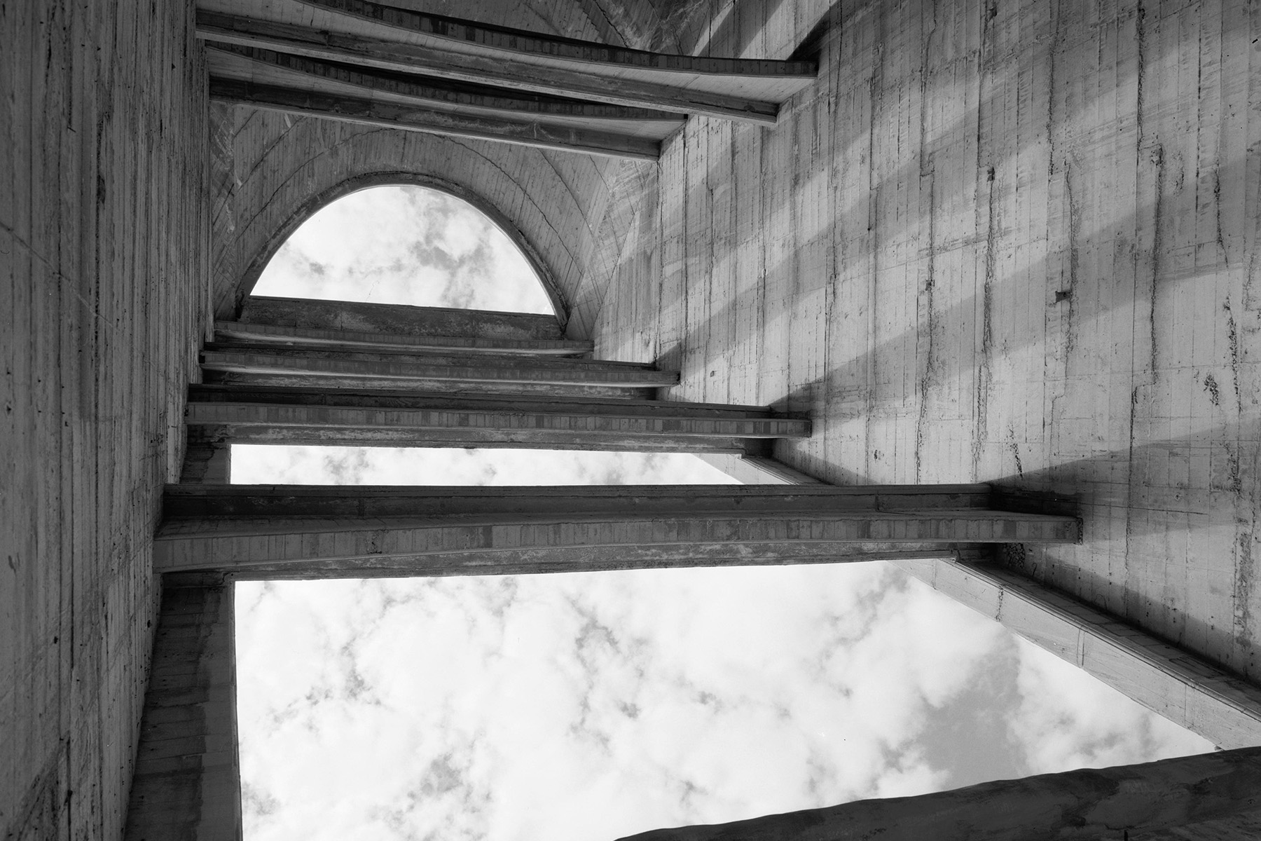 Photograph shows the inside of a dam buttress. A concrete strut-tie beam stabilizes the buttress.