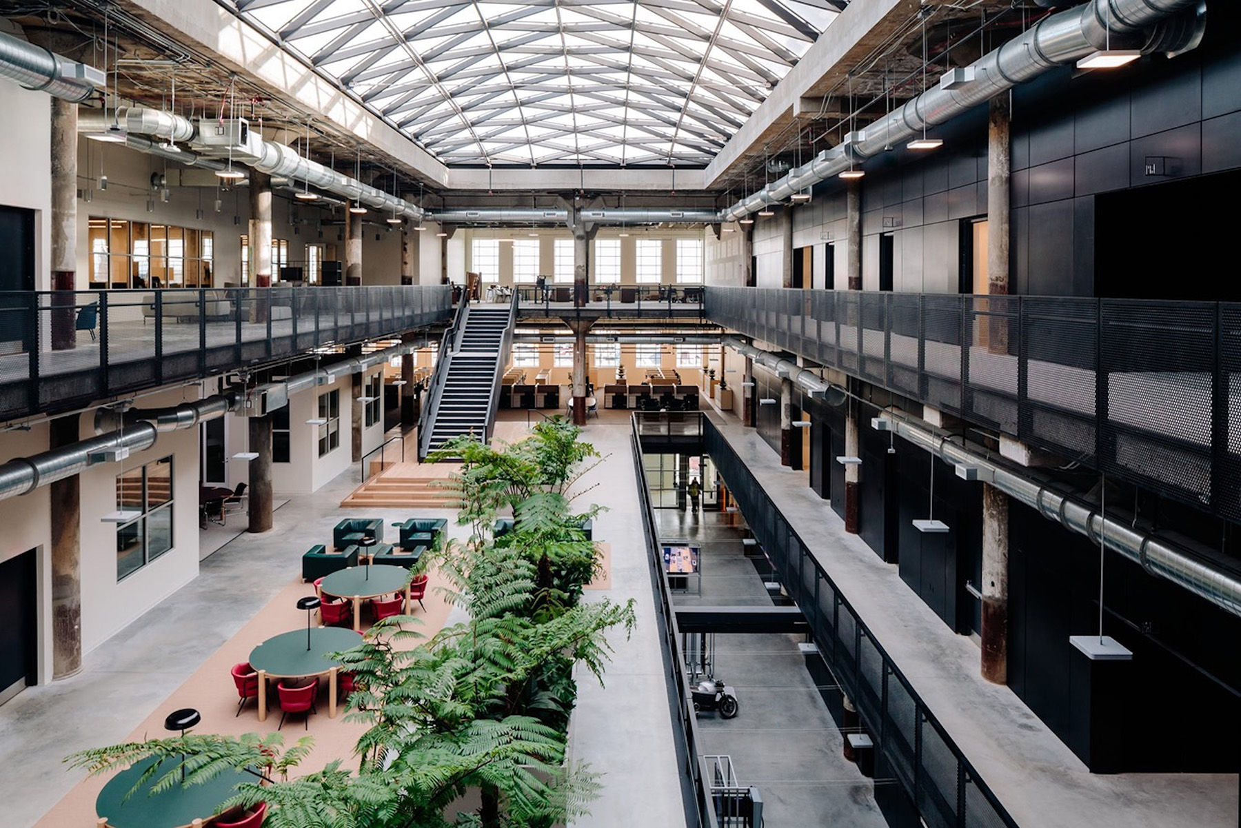 The spacious, open interior of the Newlab building is shown beneath a massive skylight.