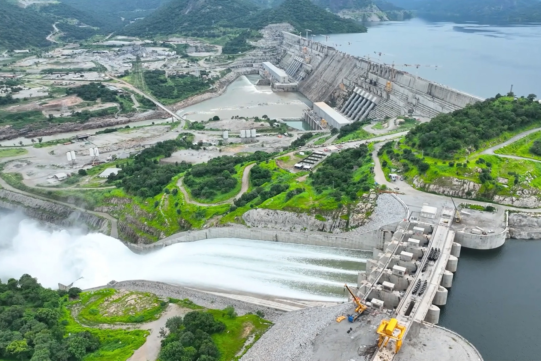 A photograph shows water rushing through the dam’s spillways.