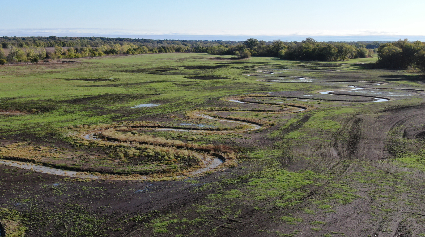 water flows in an open space surrounded by greenery